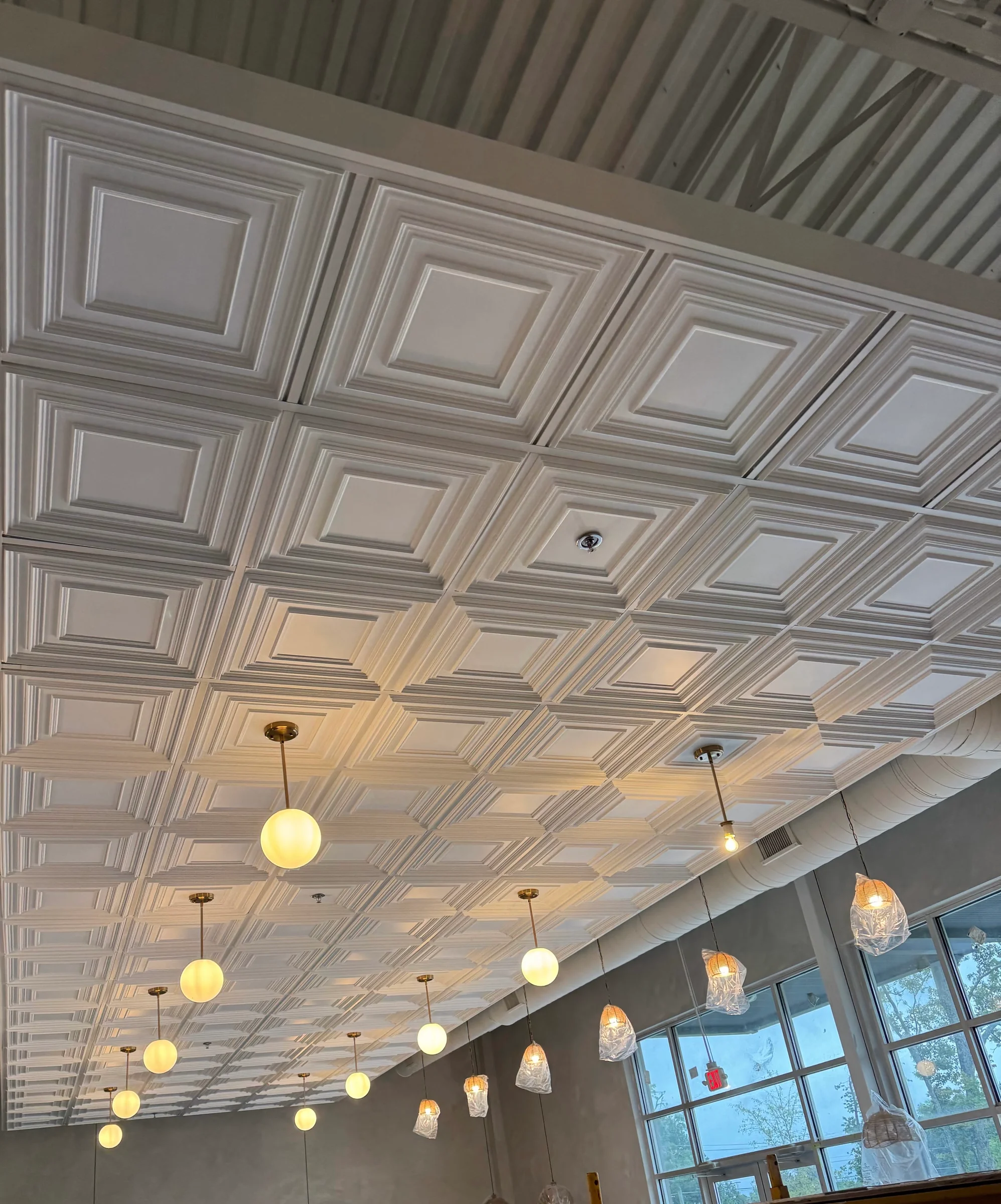 Decorative ceiling panels and architectural trim above a commercial dining space