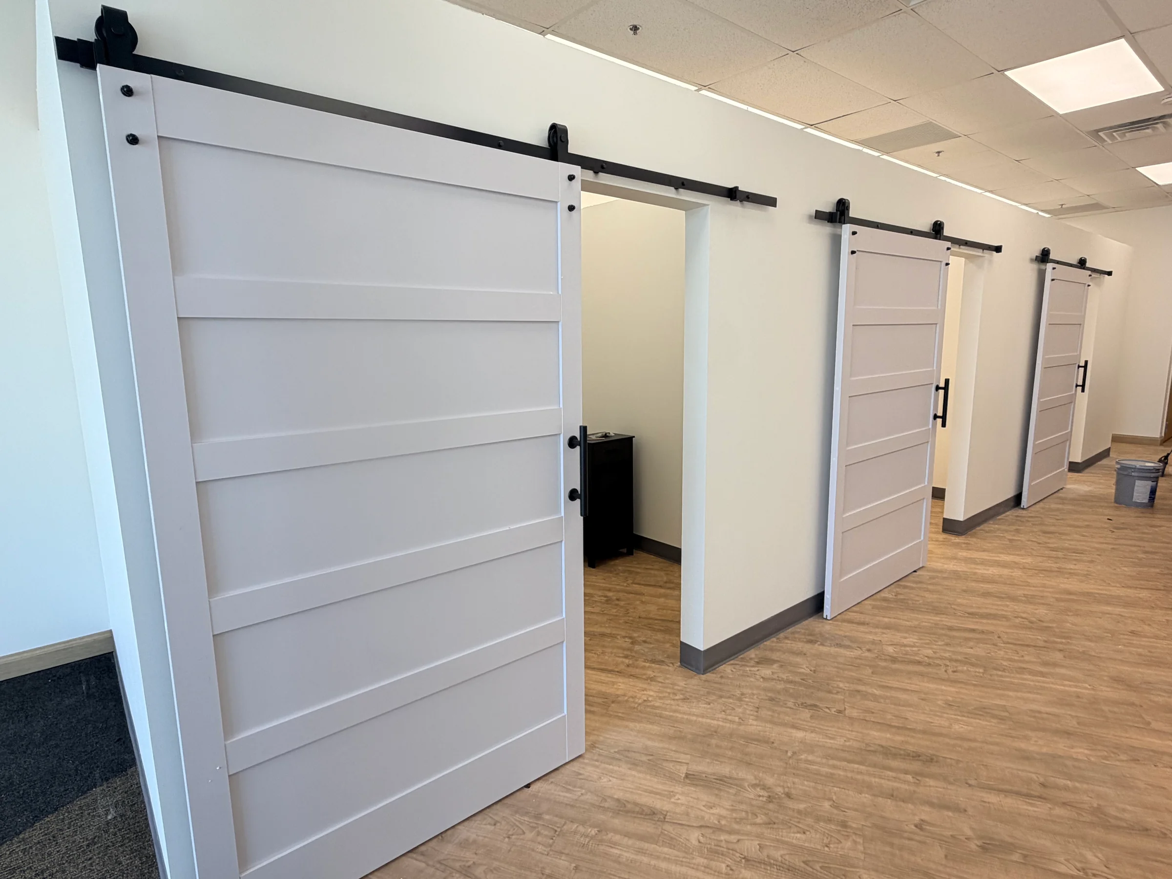 Finished commercial hallway with white walls and sliding doors